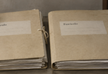 Fascicoli processuali e codici di diritto e procedura penale su una scrivania.